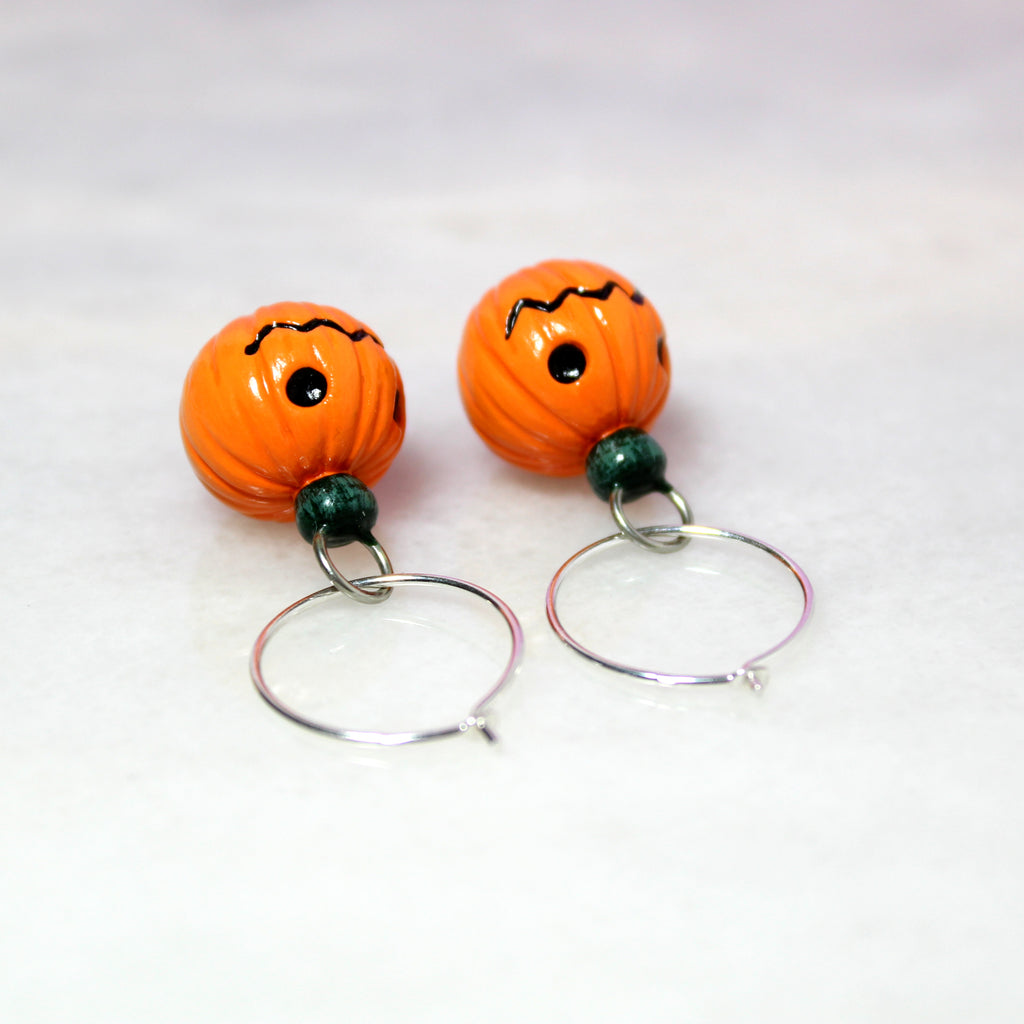 A closeup of the sterling silver hoops used in the jack o lantern earrings. They are thin and delicate, made with .925 grade sterling silver, and 19mm round.